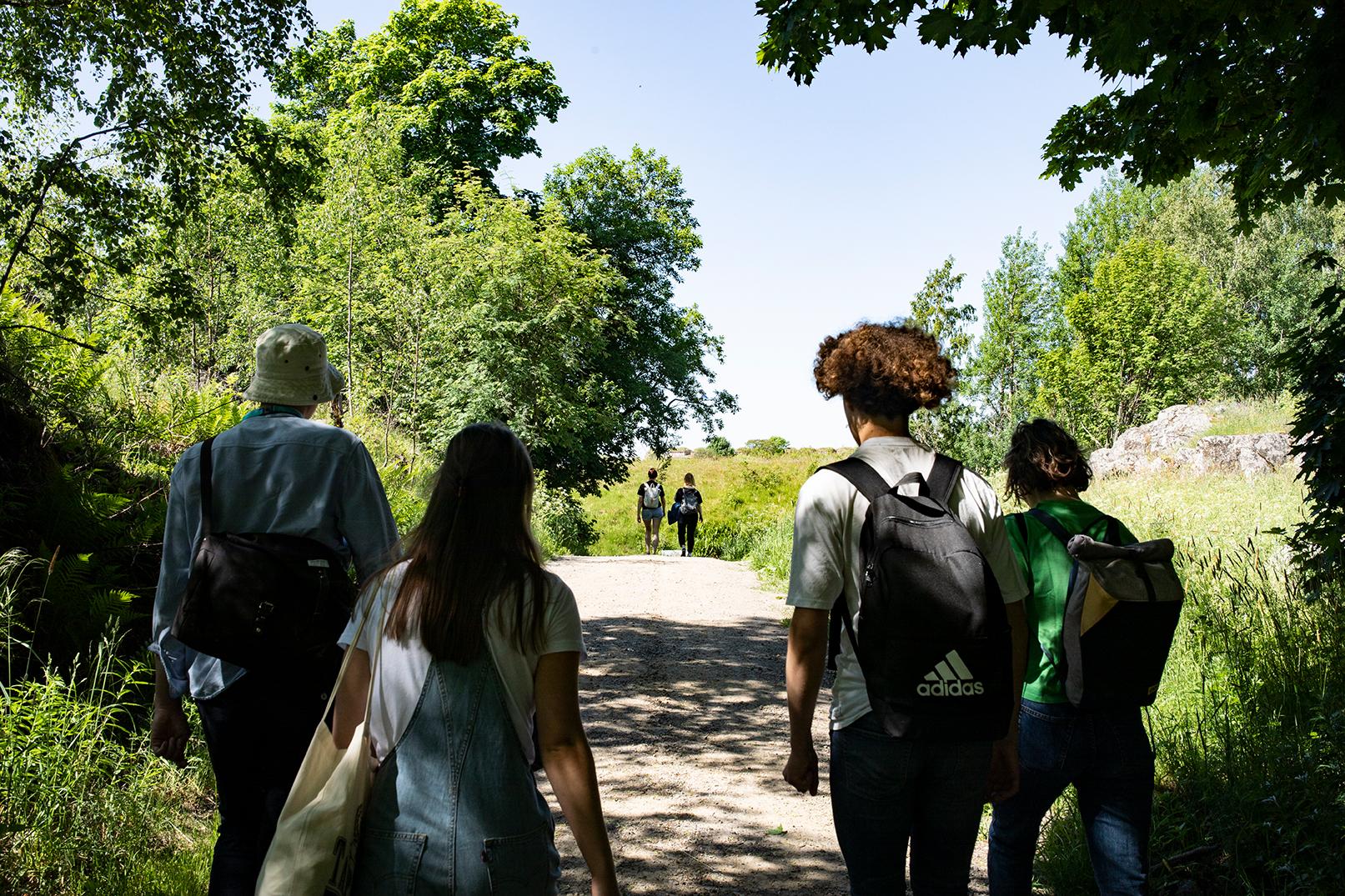 Young adults walking on a nature path during summer.