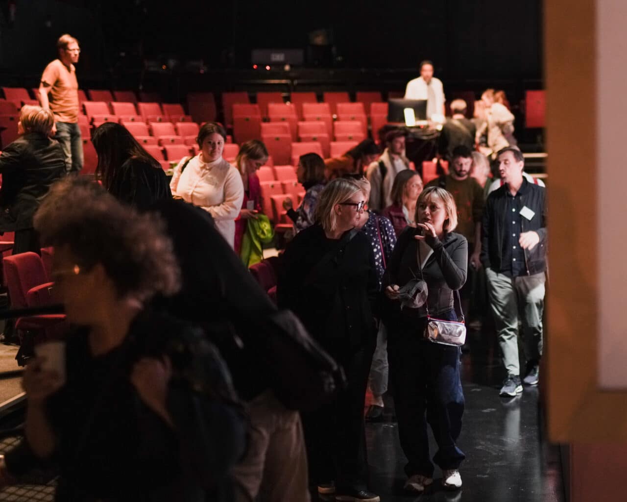 People exciting a theatre hall.