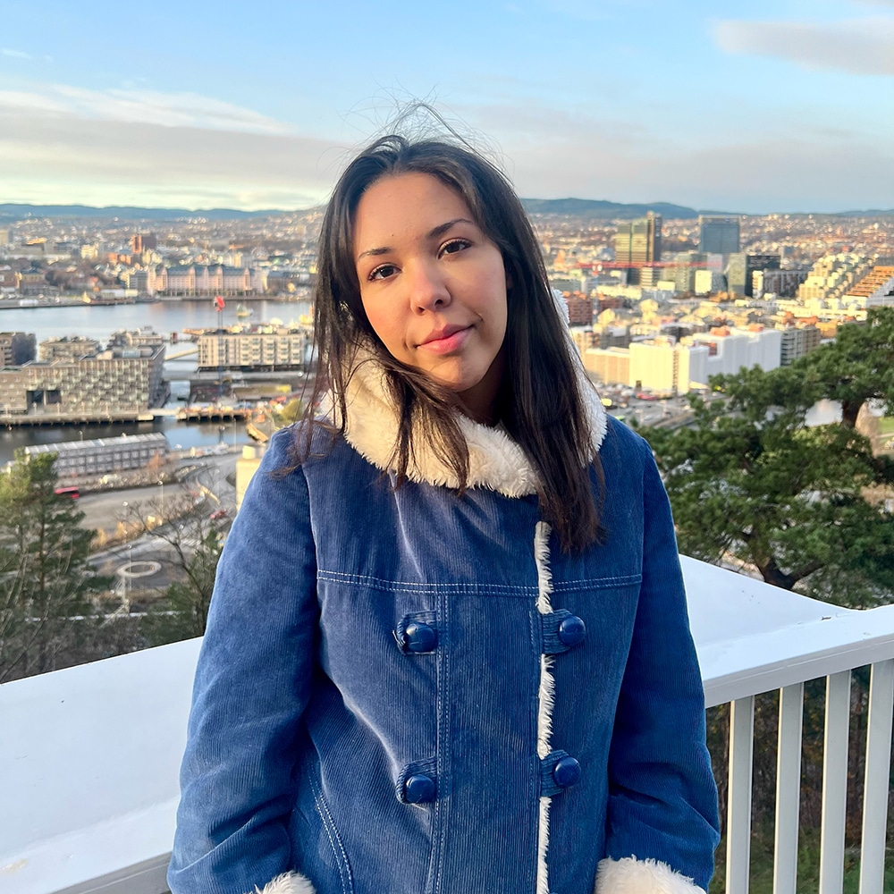 Kvinne som står foran en utsikt over Oslo.