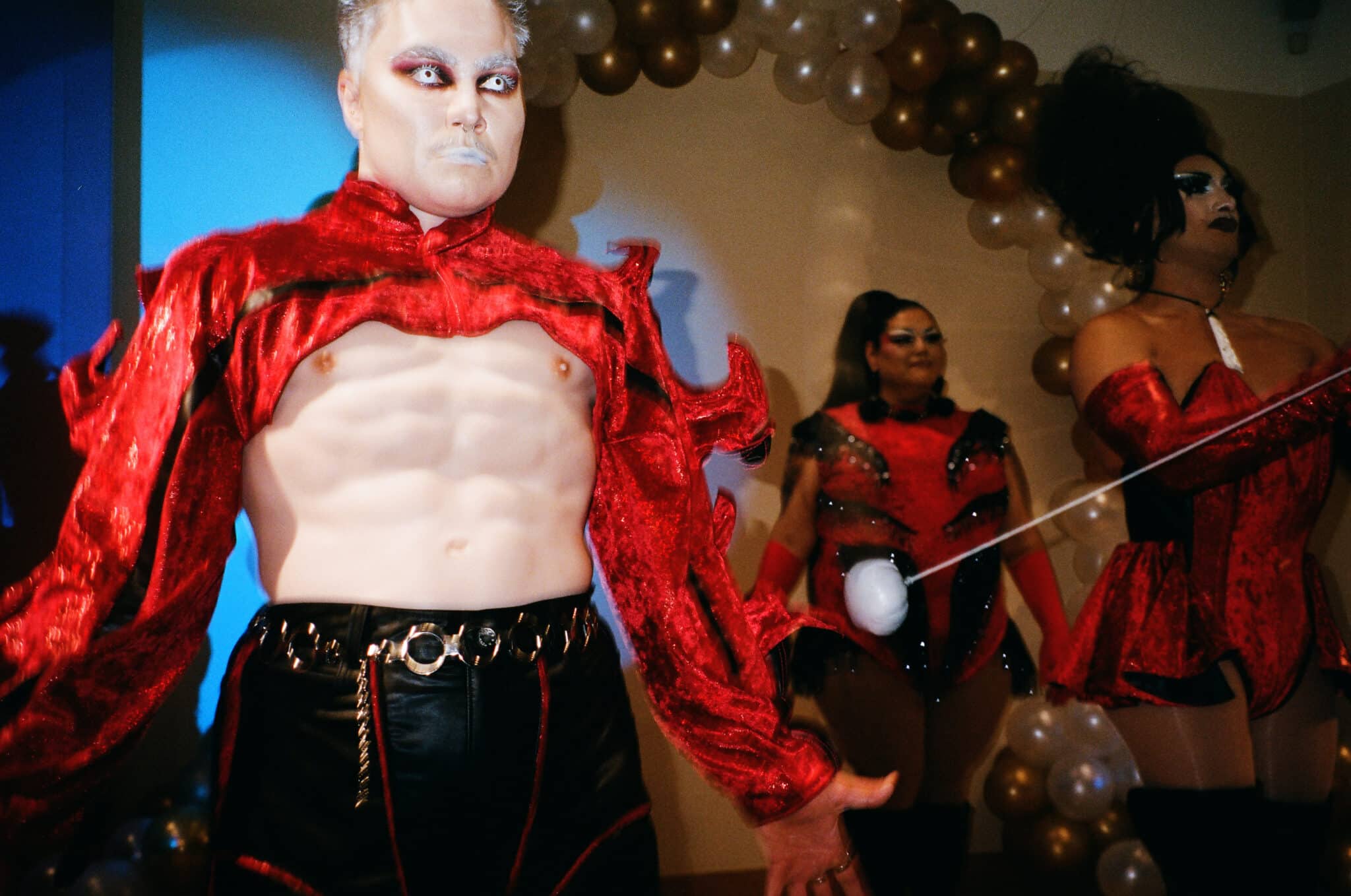 Drag king photographed flexing muscles.