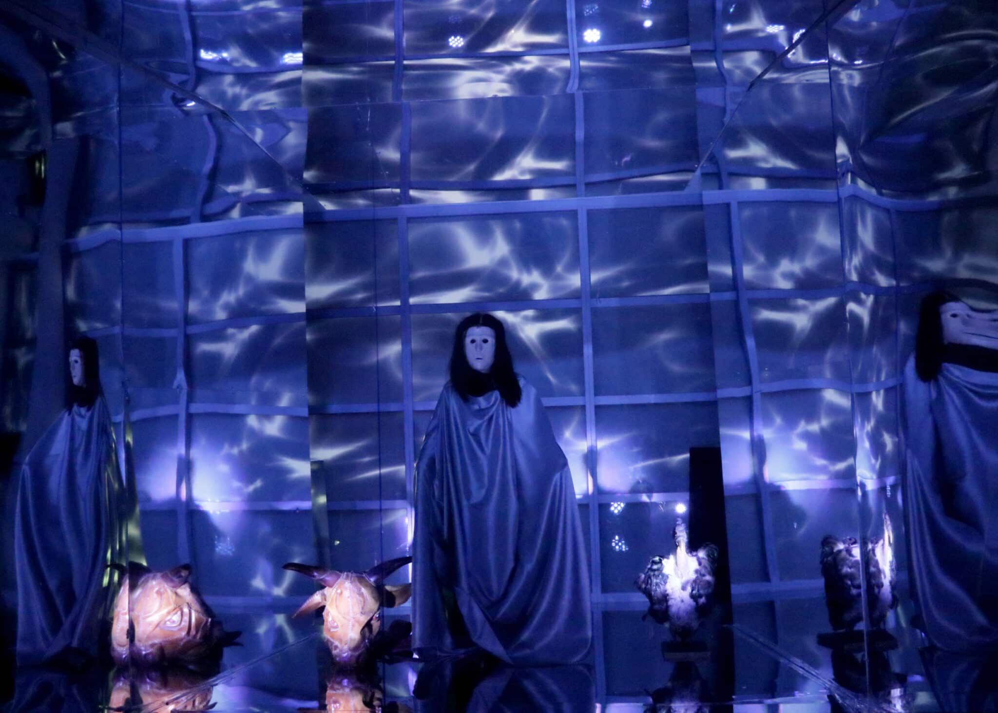 A photo from the performance SILENCE showing a blue figure surrounded by lanterns.