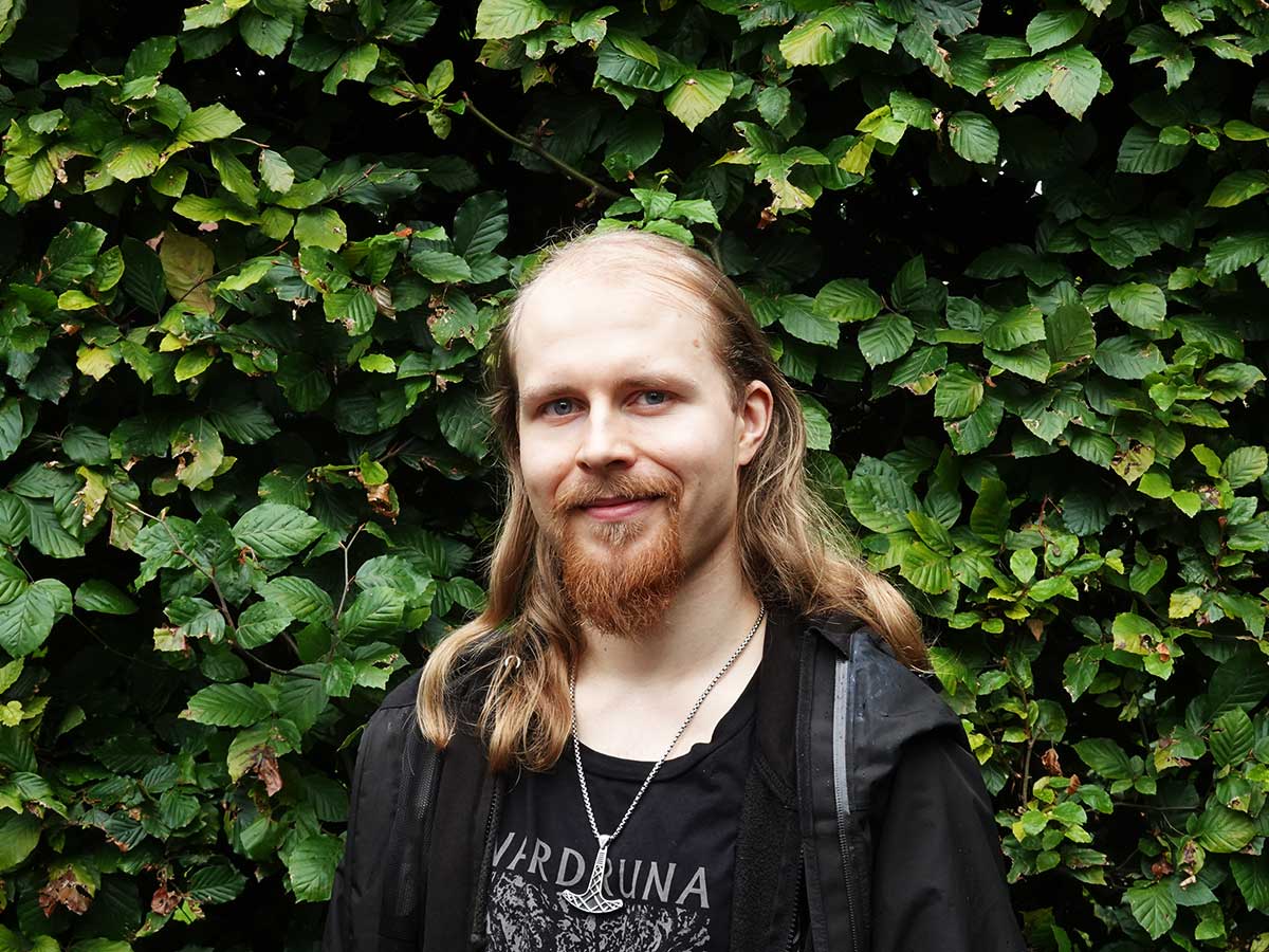 Close-up of a man in front of a ducidious tree.