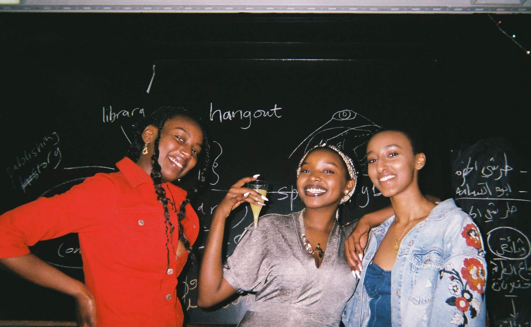Founders of Ubuntu Film Club smiling in front of a black board