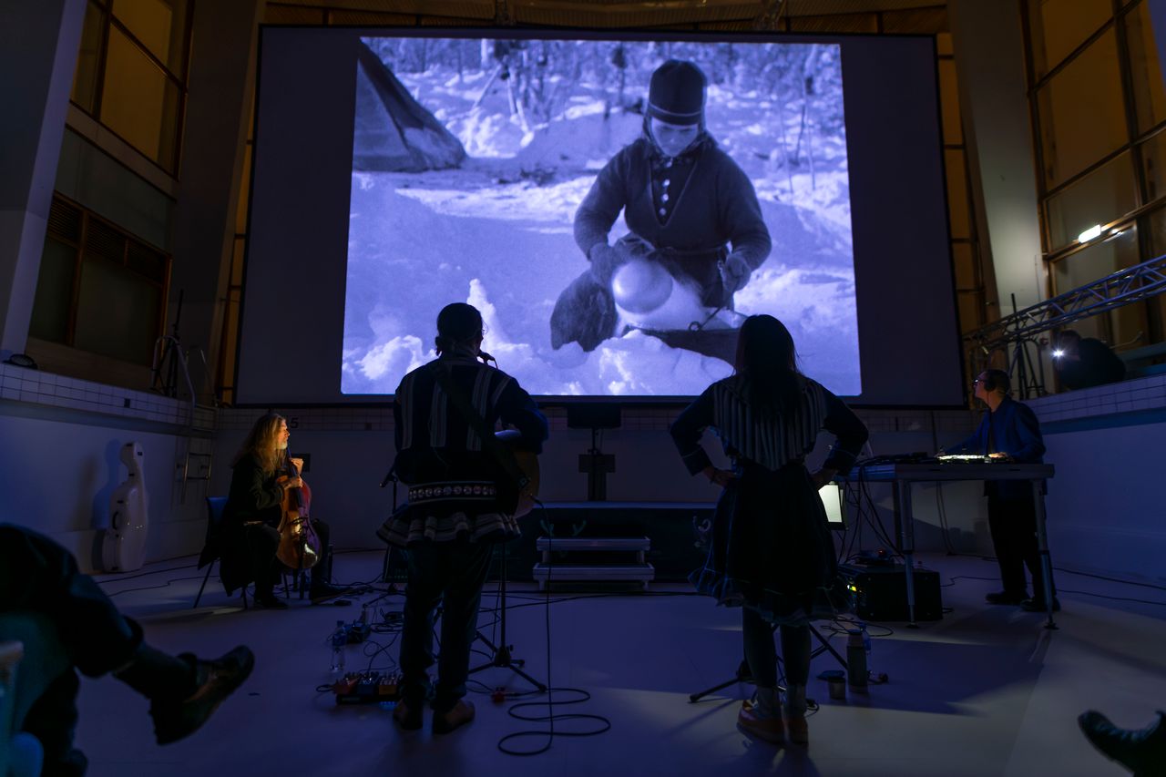 Musiker spiller foran en filmlerret.